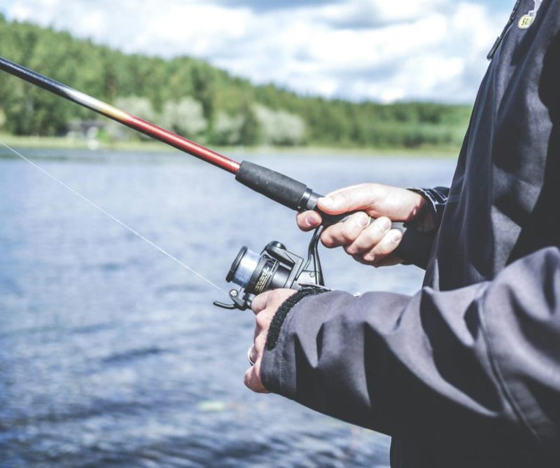 Kuvassa henkilöllä virveli kädessä ja taustalla vesistö.