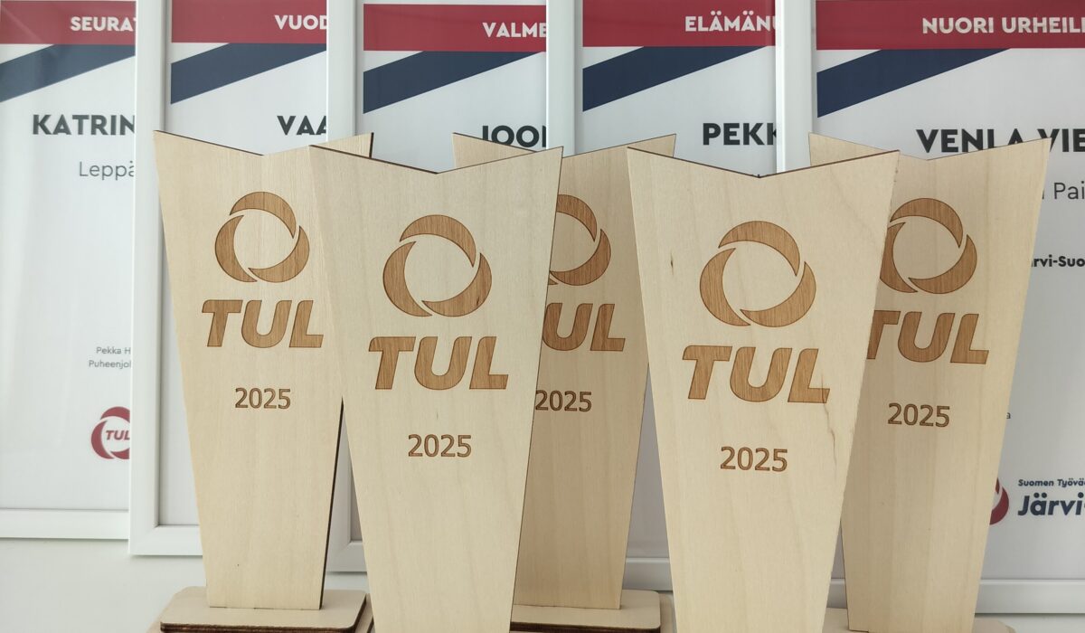 Kuvassa TUL pokaaleja ja taustalla kehystettyjä kunniakirjoja.