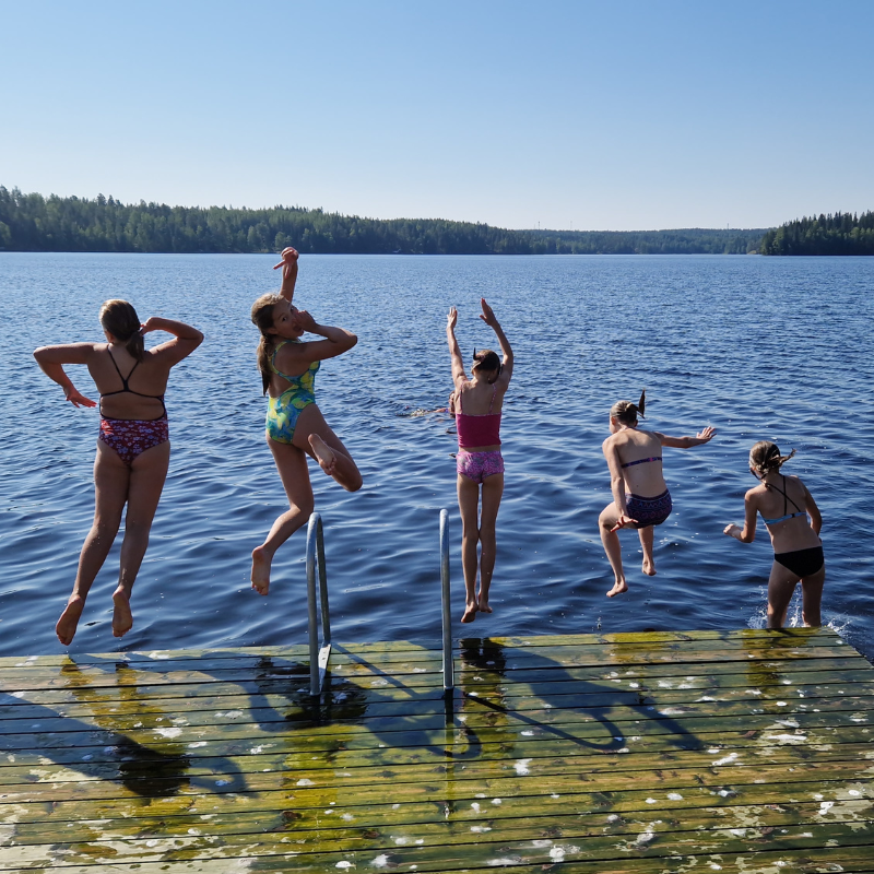 Lapset hyppäävät laiturilta järveen