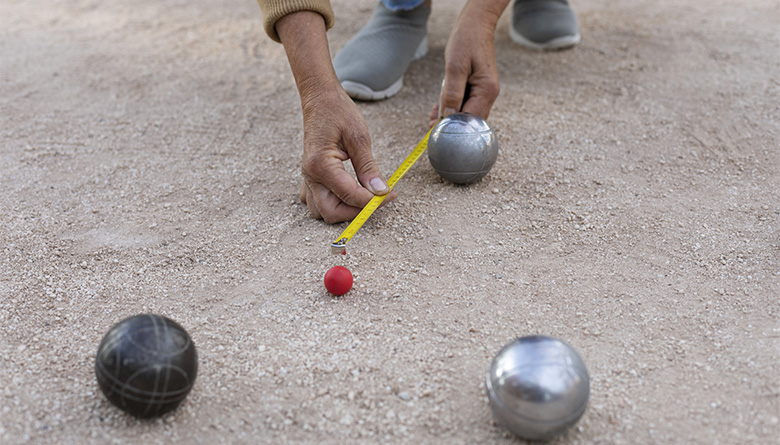 Kuvassa mitataan petankkikuulien etäisyyksiä snadista.