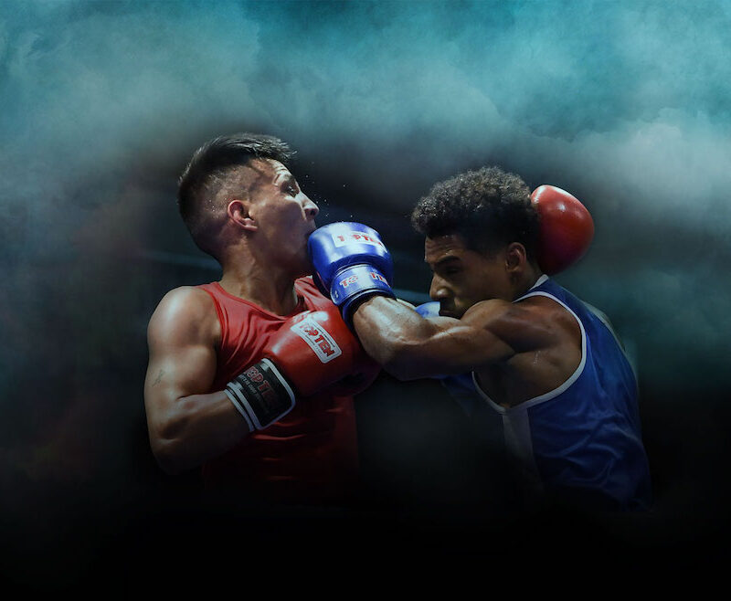 Kaksi nyrkkeilijää, takana tumma ja sumuinen tausta.