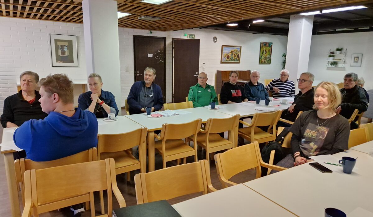 Kokousväkeä pöydän ympärillä