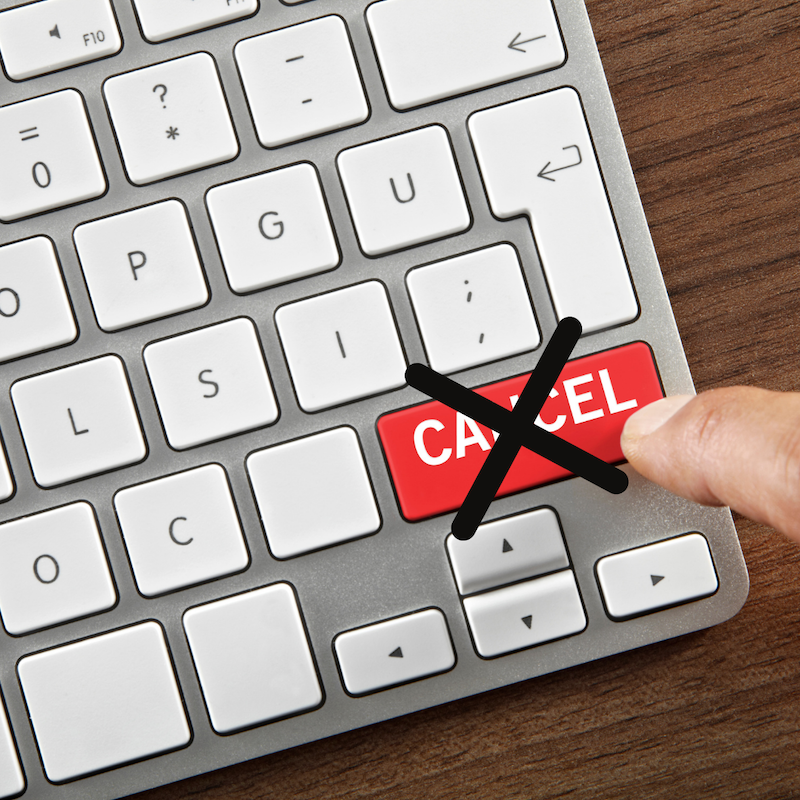 Tietokoneen näppäimistö. Sormi painaa punaista Cancel-näppäintä.