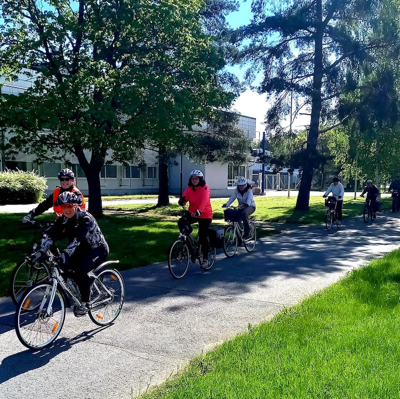 Polkupyöräretkellä pyöräilijät jonossa aurinkoisella säällä.