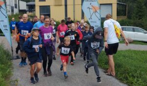 Valttimaili. Joukko lasia nuoria ja aikuisia on juuri lähtenyt juoksemaan hiekkatietä pitkin lähtöviivalta.