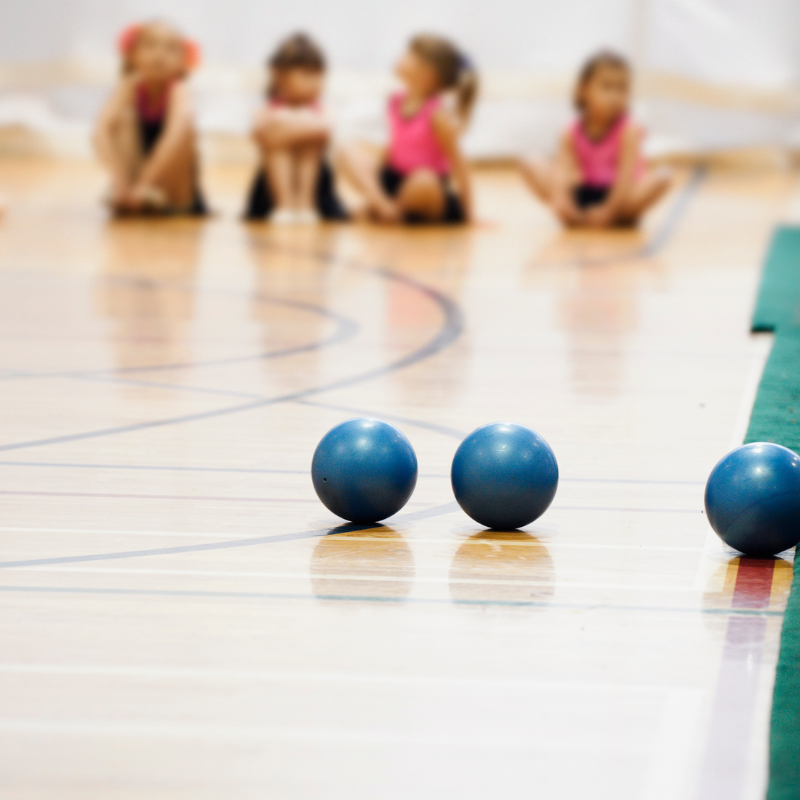 Voimistelupalloja ja taustalla lapsia venyttelemässä.