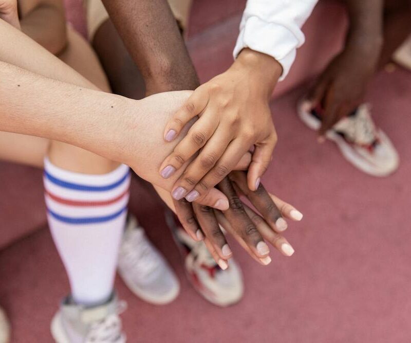 Urheilujoukkueen kädet yhdessä.