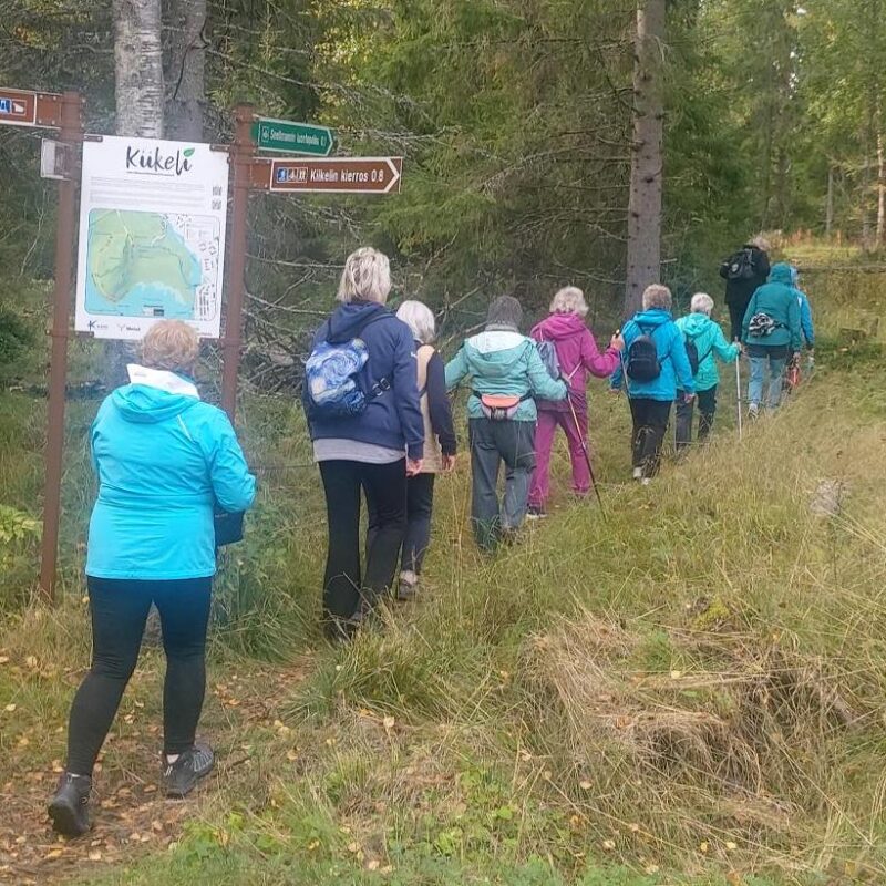 Kävelijöitä selin kameraan Kemissä Kiikelin alueella luonnon keskellä.