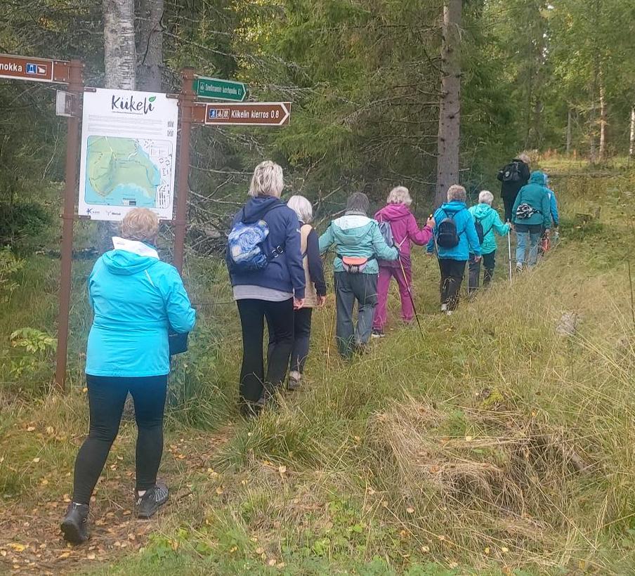 Kävelijöitä selin kameraan Kemissä Kiikelin alueella luonnon keskellä.