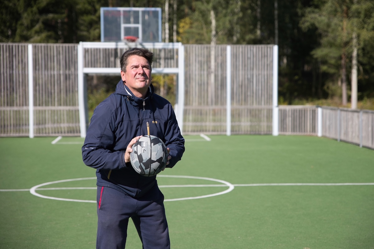 Saku Nikkanen jalkapallo käsissään urheilukentällä.