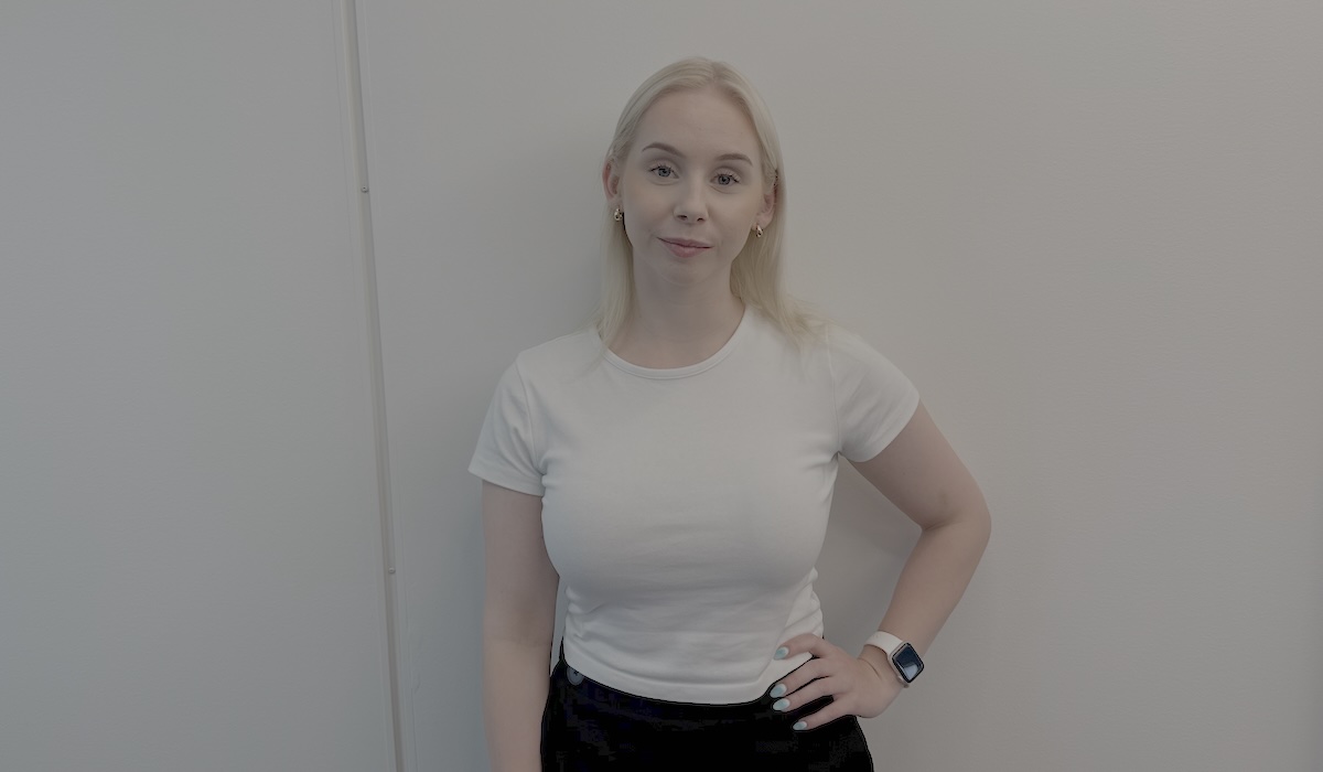 Miisa Makkonen kuvattuna seisomassa vaalean seinän edustalla.