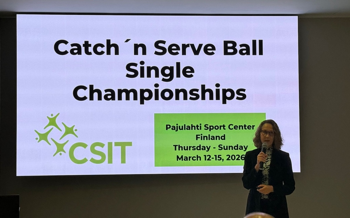 Anu Rajajärvi pitää puhetta CSIT:n yleiskokouksessa 2025. Taustalla näkyvässä diassa teksti Catch'n serve ball single championships sekä CSIT:n vihreä logo.