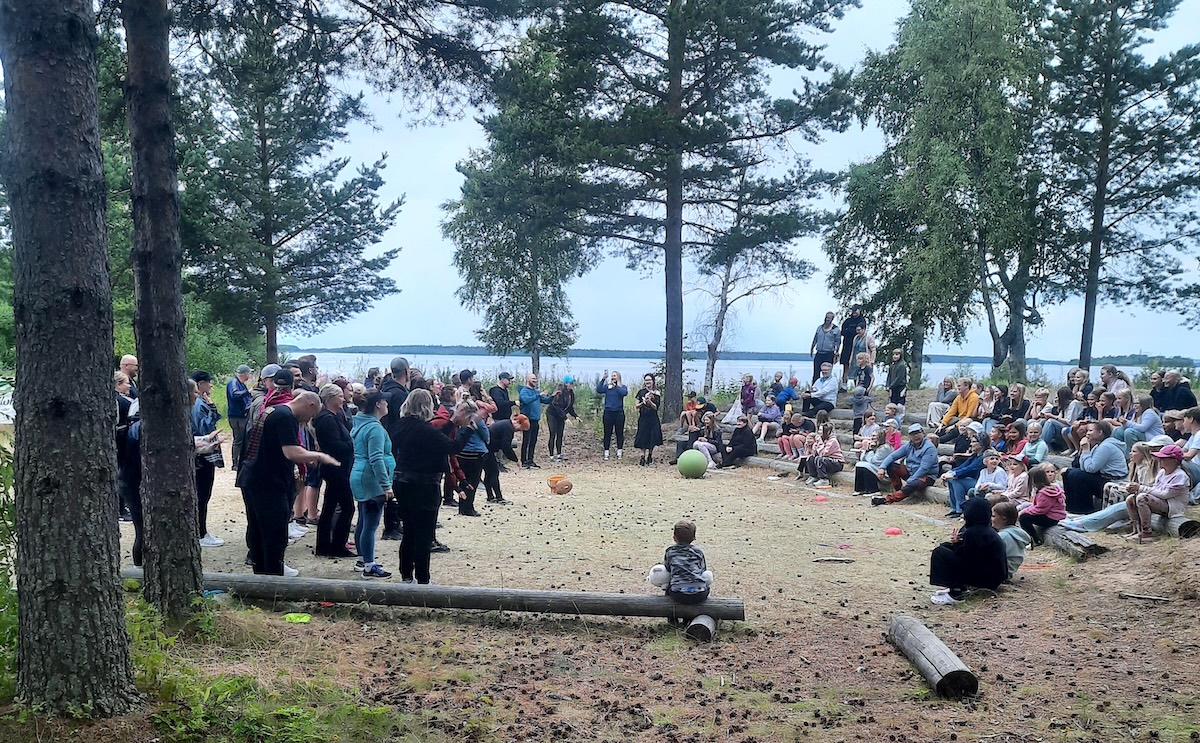 Lete-leirin osallistujia ja heidän vanhempiaan kuvattuna kaukaa luonnon keskellä.