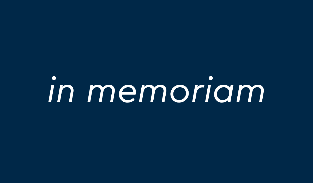 Tummansinisellä taustalla valkoinen teksti in memoriam.